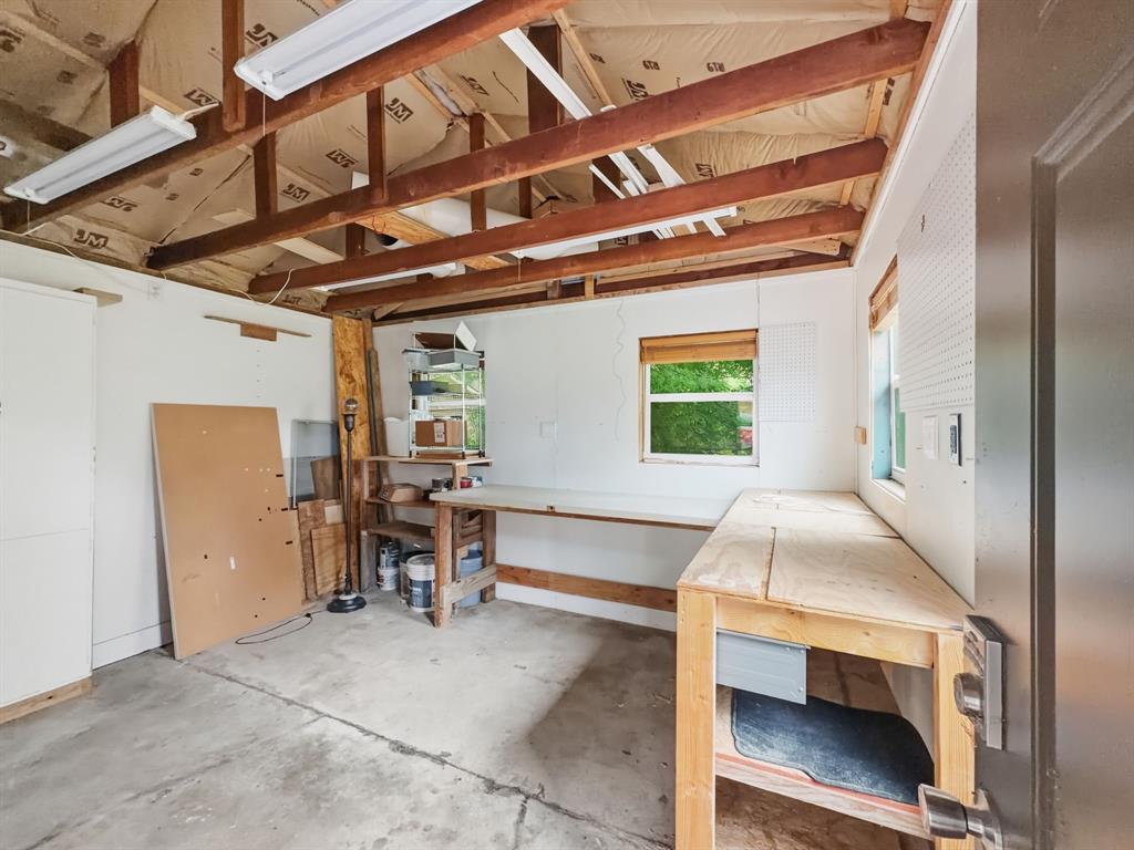 2137 Lenamon Street Waco, TX 76710 - Photo 27 of 29 Workshop space featuring exposed ceiling beams, concrete flooring, dual windows, and built-in wood workbenches