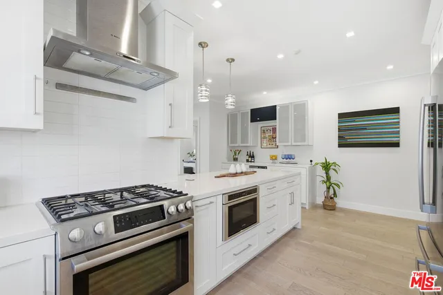 a kitchen with a stove and white cabinets