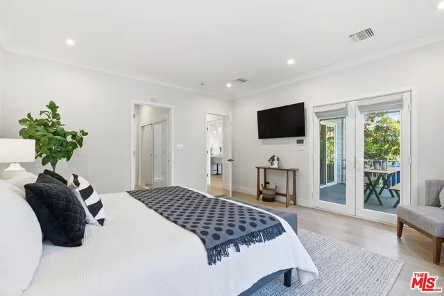 a bedroom with a bed and a flat screen tv