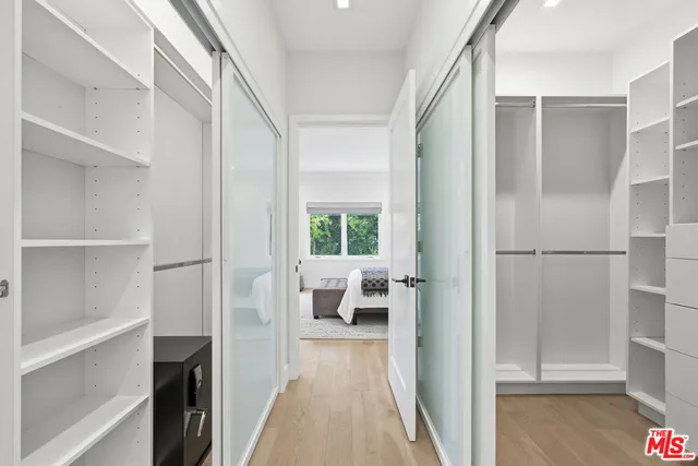 a view of a bedroom with wooden floor and windows