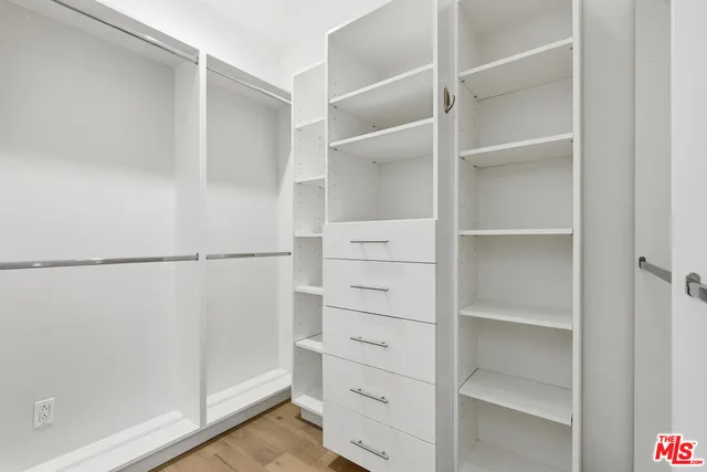a view of walk in closet with empty racks