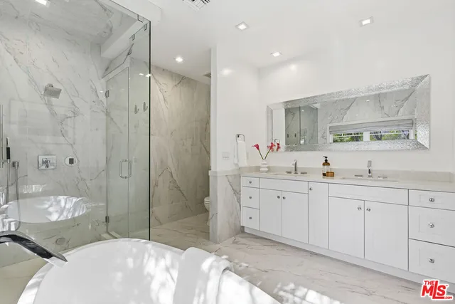 a spacious bathroom with a double vanity sink mirror and shower