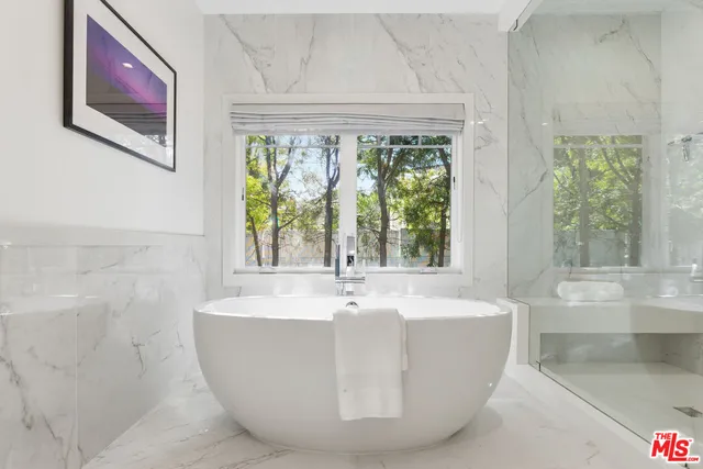 a white bath tub sitting in a bathroom next to a window