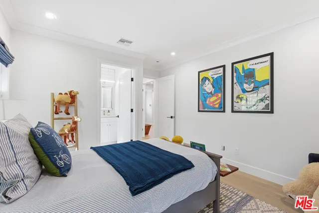 a bedroom with a bed and a painting on the wall