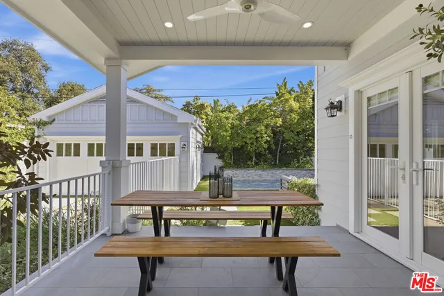 a backyard view with a couple of couches and potted plants