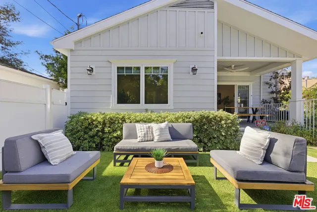 a view of a patio with couches table and chairs and potted plants
