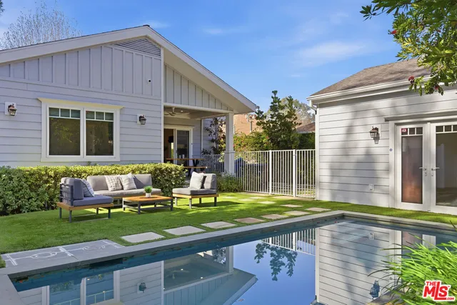 a view of a house with backyard and sitting area
