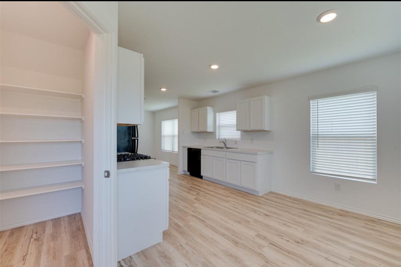 11020 South Lake Mist Lane Willis, TX 77318 - Photo 12 of 27 a large kitchen with kitchen island a sink dishwasher a stove and a refrigerator with wooden floor