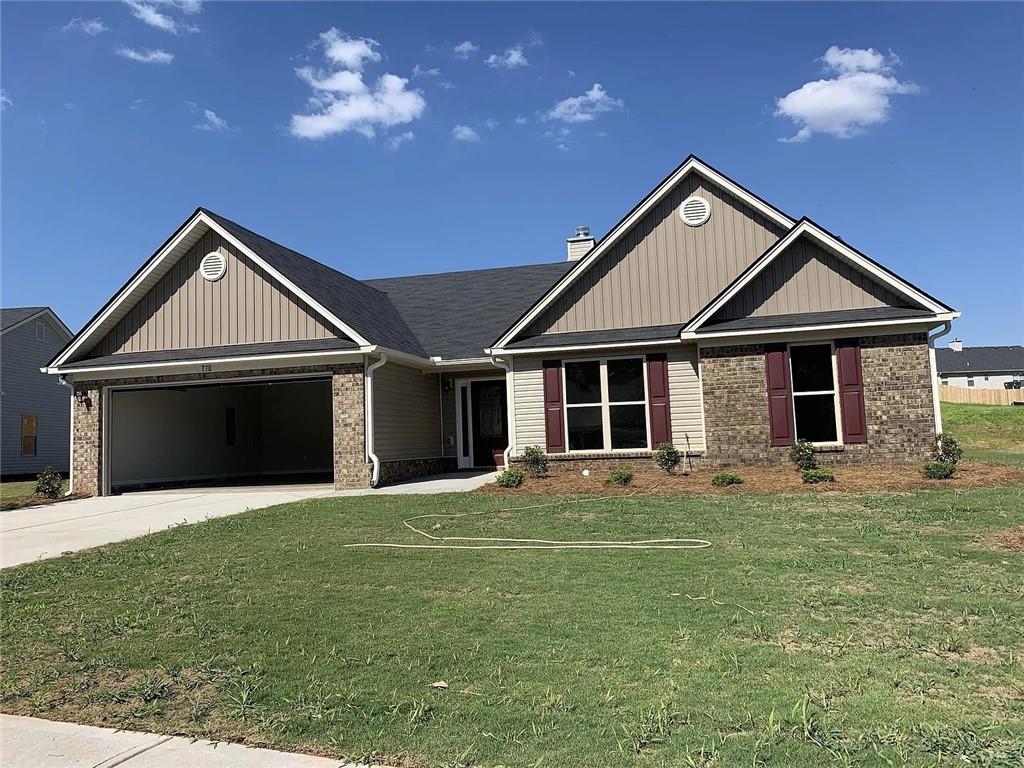 a front view of a house with a garden and yard