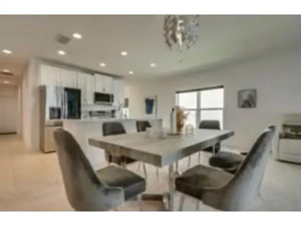 a dining hall with stainless steel appliances a dining table and chairs