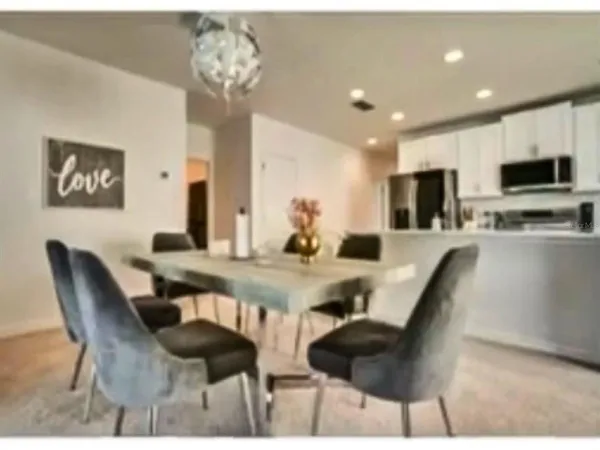 a view of a dining room with furniture and a chandelier