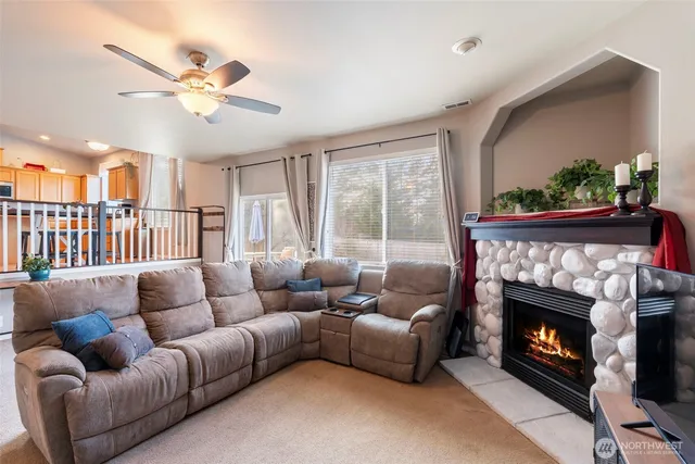 a living room with furniture a fireplace and a flat screen tv