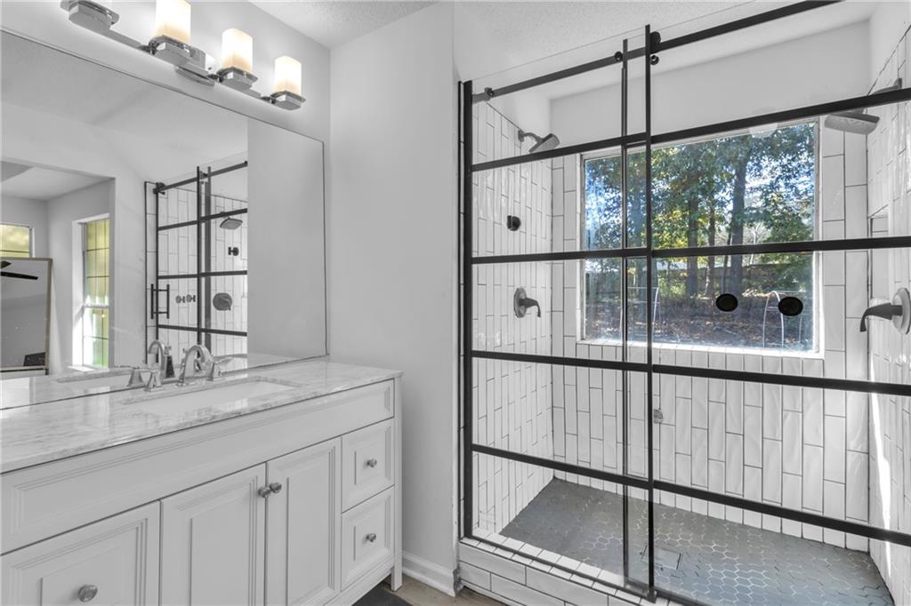 3985 Countryside Way Southwest Snellville, GA 30039 - Photo 20 of 40 a bathroom with a shower sink and mirror