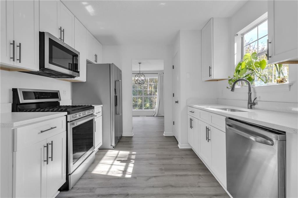 3985 Countryside Way Southwest Snellville, GA 30039 - Photo 5 of 40 a kitchen with stainless steel appliances a stove microwave and sink