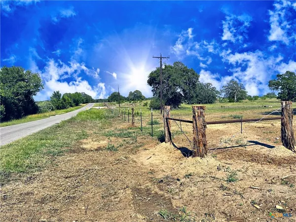 a view of a yard with wooden fence
