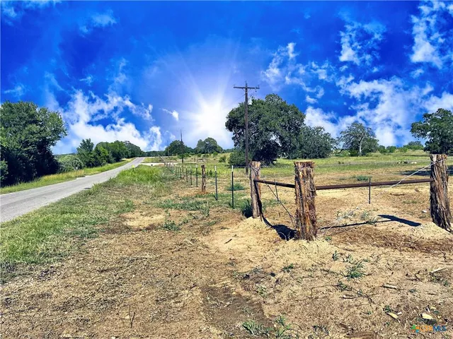 a view of a yard with wooden fence