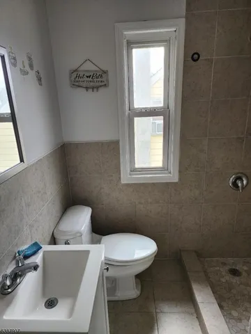 a bathroom with a sink a toilet and a window