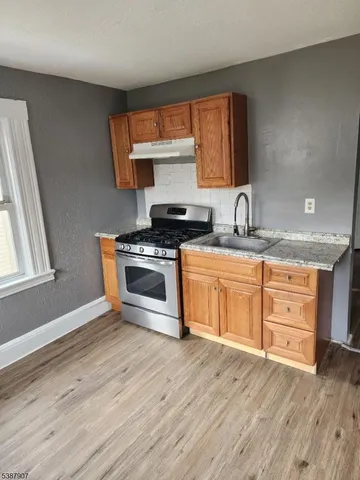 a kitchen with stainless steel appliances granite countertop a stove a sink and a microwave