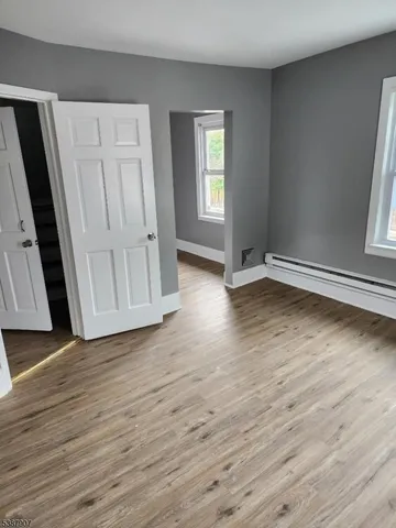 an empty room with wooden floor and window