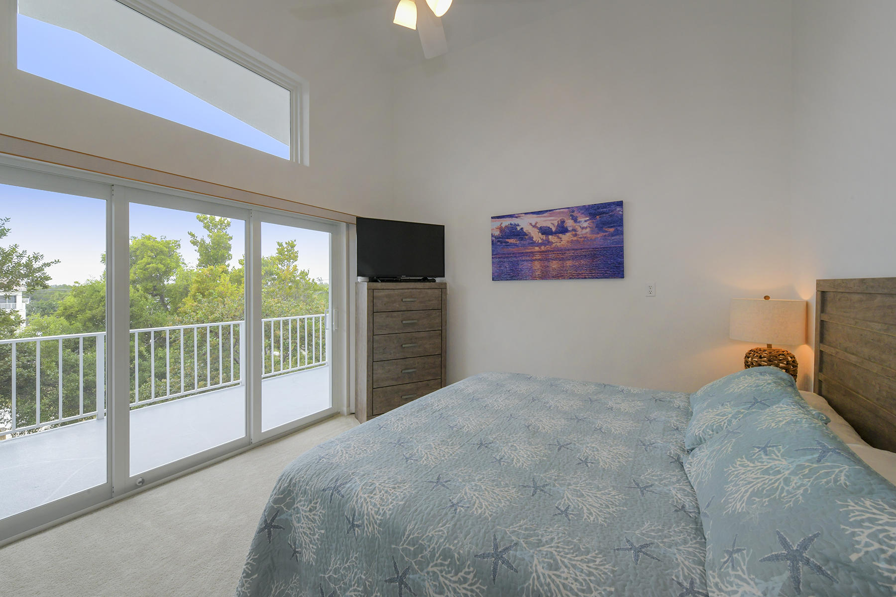 161-154 Sunset Drive Islamorada, FL 33036 - Photo 22 of 38 a view of a bedroom with a balcony bed and a tv