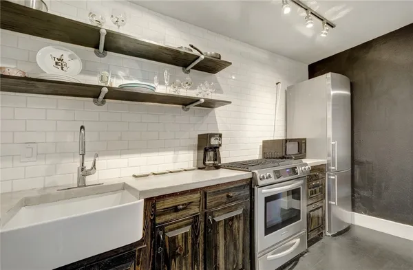 a kitchen with stainless steel appliances a stove a sink and a refrigerator