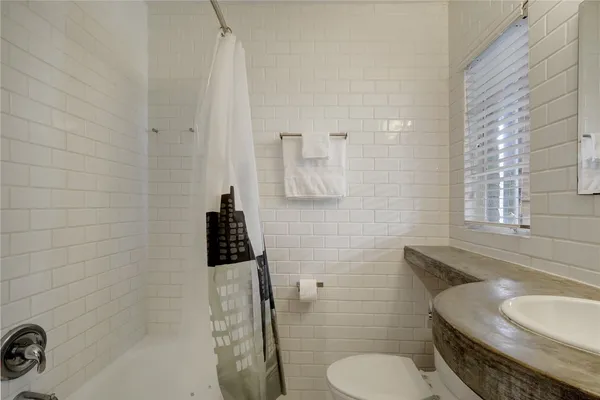 a bathroom with a granite countertop toilet sink and mirror
