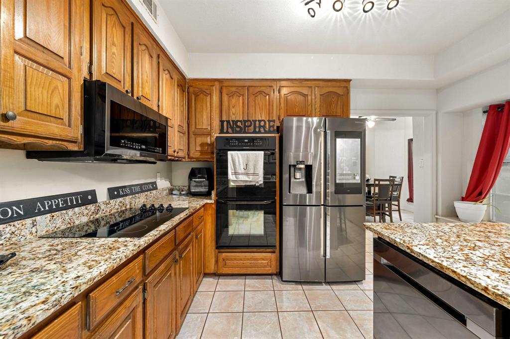 104 Pecan Grove Lancaster, TX 75146 - Photo 13 of 33 a kitchen with stainless steel appliances granite countertop a refrigerator stove and oven