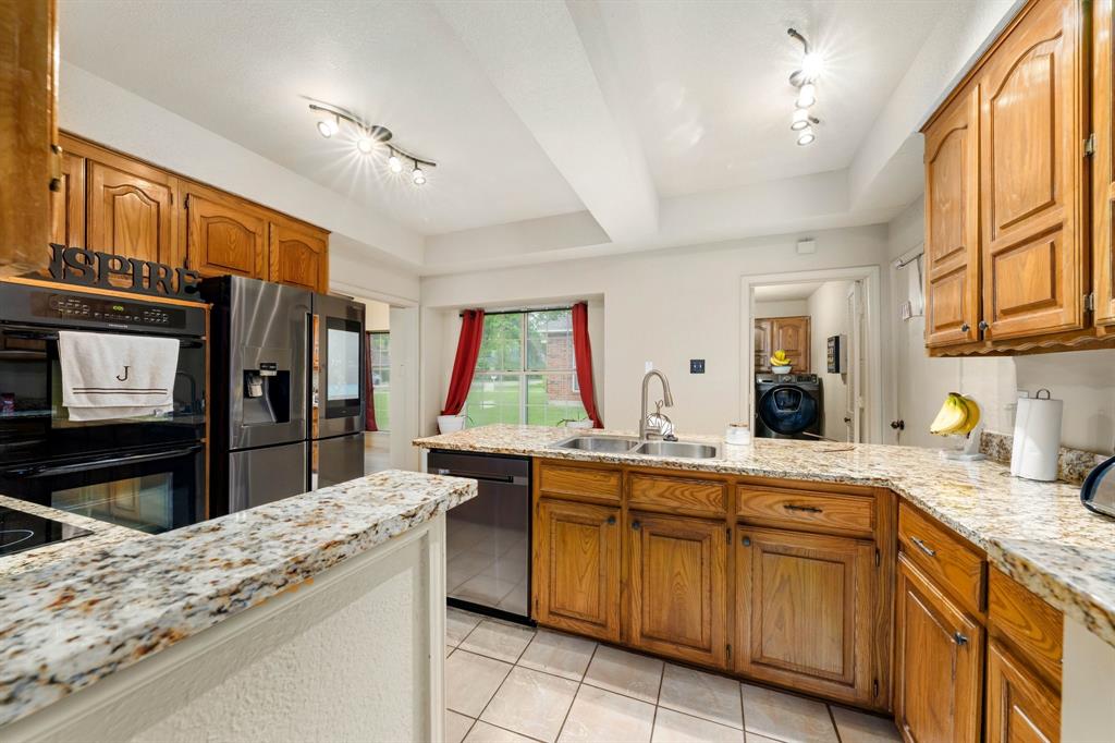 104 Pecan Grove Lancaster, TX 75146 - Photo 14 of 33 a kitchen with stainless steel appliances kitchen island granite countertop a sink stove and refrigerator