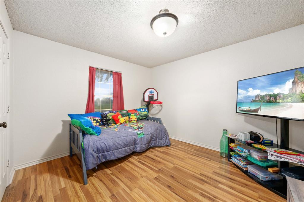 104 Pecan Grove Lancaster, TX 75146 - Photo 28 of 33 a bedroom with furniture and a wooden floor
