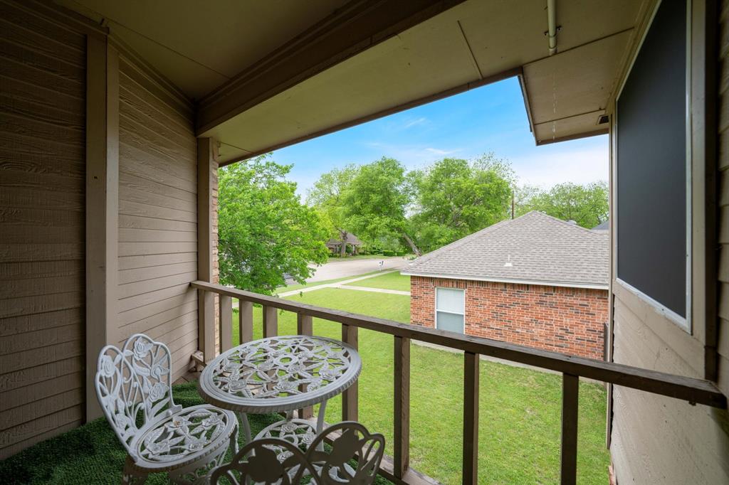 104 Pecan Grove Lancaster, TX 75146 - Photo 33 of 33 The property features a balcony with wooden railings and a textured exterior wall
