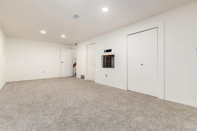 an empty room with a cabinet and mirrors