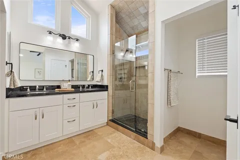 a bathroom with a granite countertop sink mirror and shower