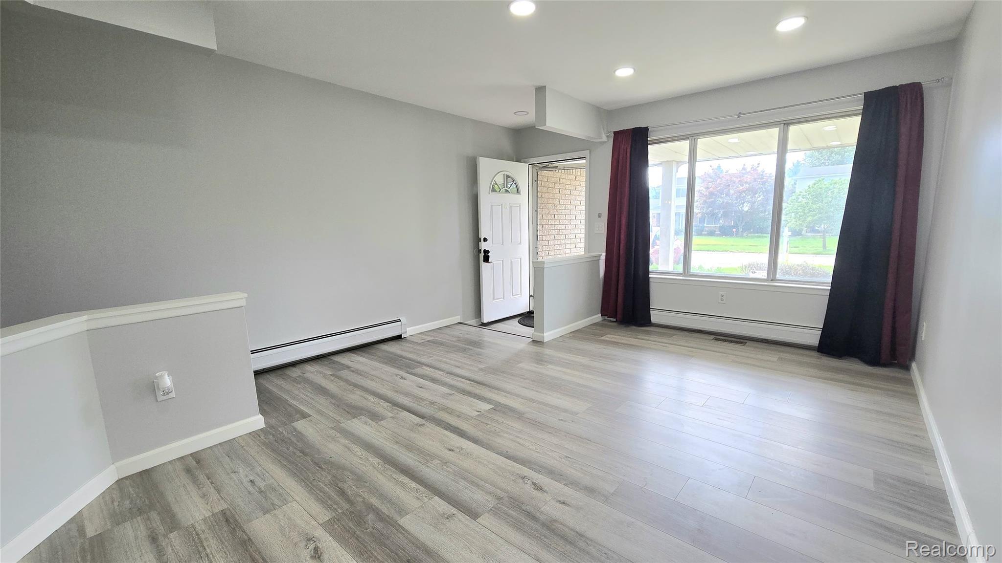 34294 Greentrees Road Sterling Heights, MI 48312 - Photo 4 of 20 Spacious room with wood-finish flooring, recessed lighting, large windows, and a white entry door