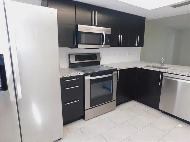 a kitchen with a sink and steel appliances