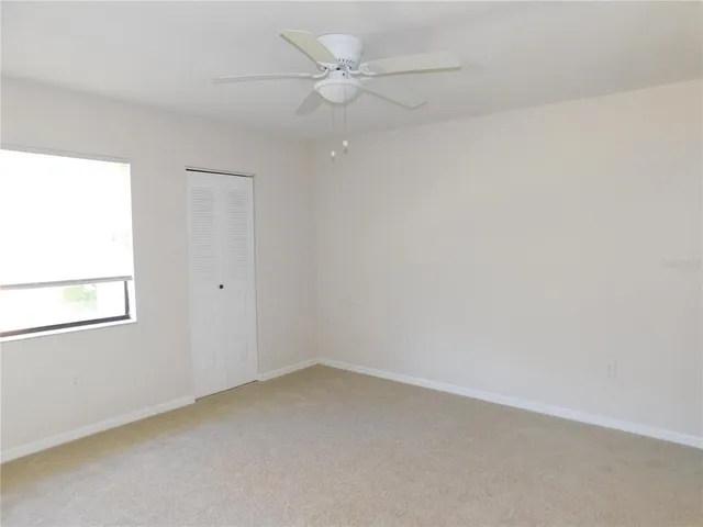 an empty room with a window and a fan