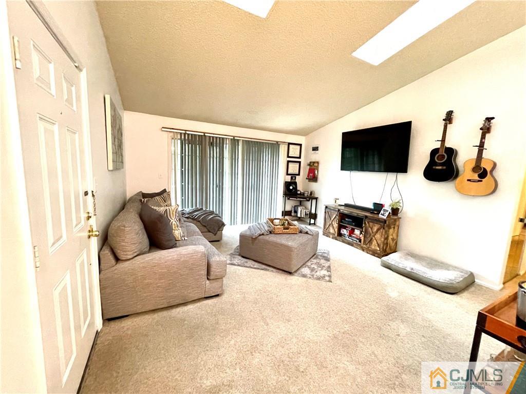 341 Wimbeldon Court North Brunswick, NJ 08902 - Photo 2 of 16 a living room with furniture and a flat screen tv