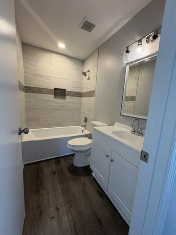 a bathroom with a double vanity sink a toilet and mirror