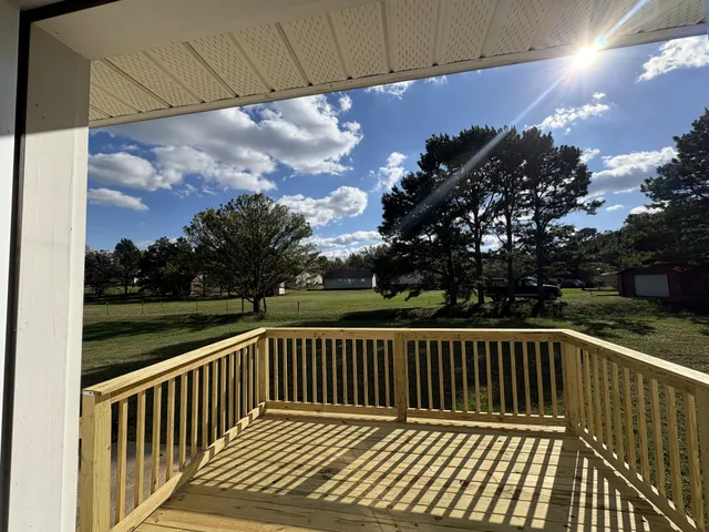 a view of balcony with wooden floor and fence