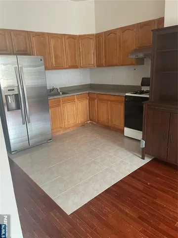 a kitchen with a refrigerator sink and cabinets