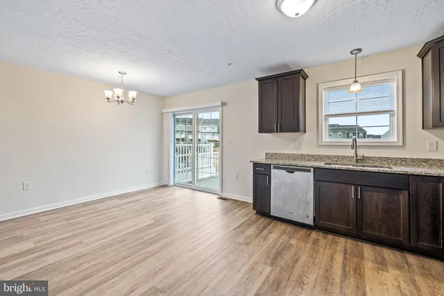 a kitchen with stainless steel appliances granite countertop a sink cabinets and wooden floor
