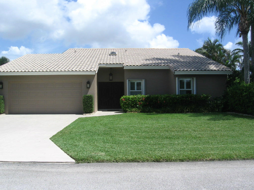 245 Northwest 70th Street Boca Raton, FL 33487 - Photo 2 of 39 a front view of a house with a garden