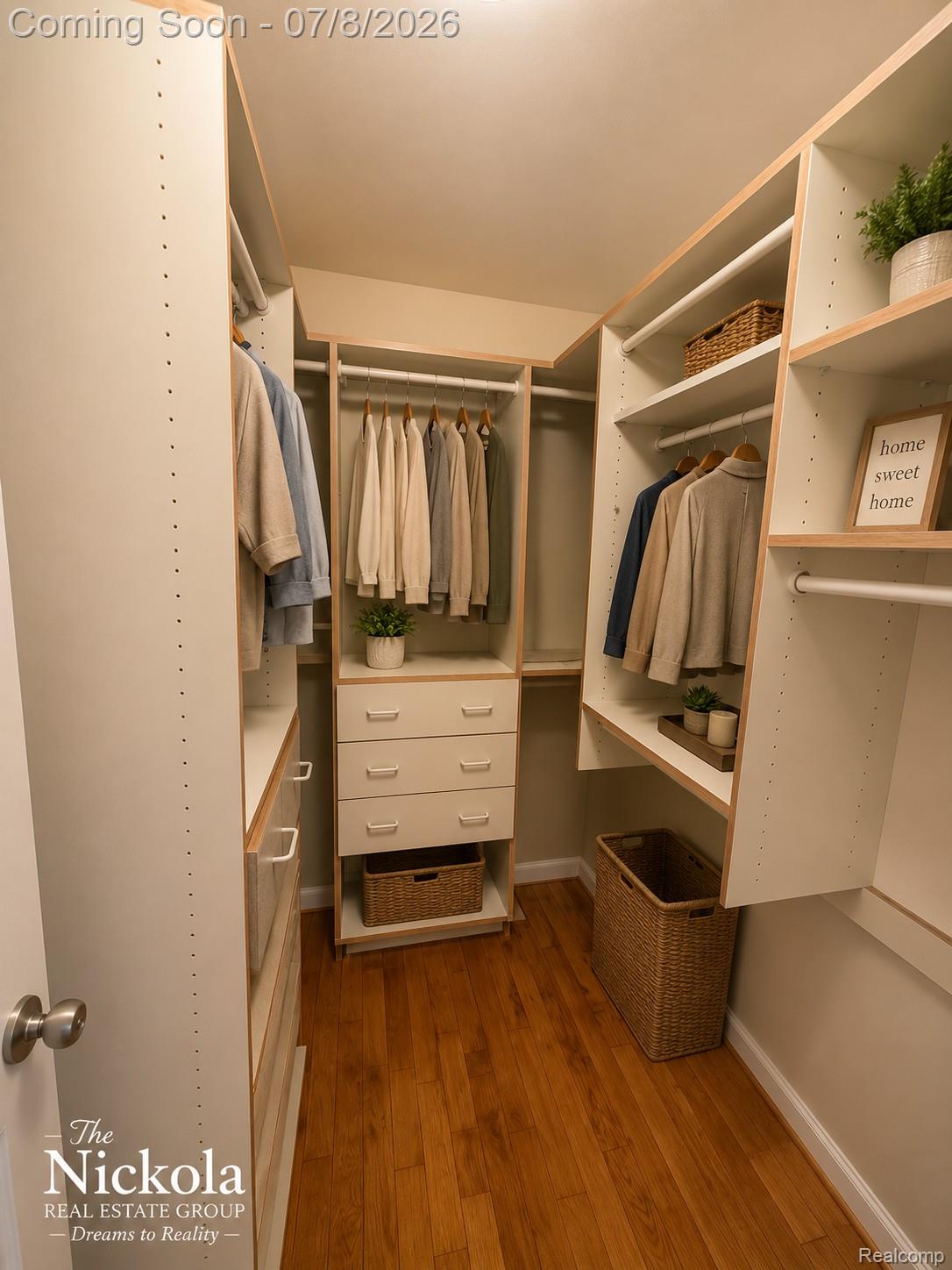 414 Whitney Drive Rochester, MI 48307 - Photo 20 of 30 Walk-in closet featuring wood-finish flooring, built-in shelving, integrated hanging rods, and a central dresser with drawers