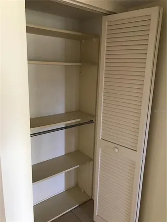 a view of walk in closet with empty racks