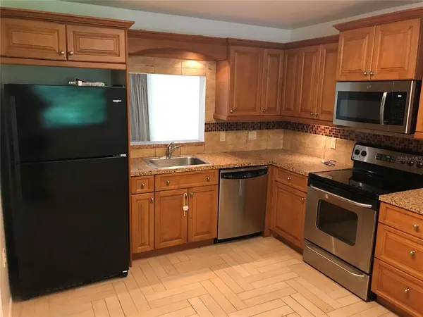 a kitchen with stainless steel appliances granite countertop a stove a refrigerator and a microwave
