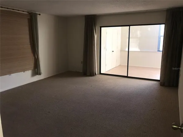 an empty room with windows and closet