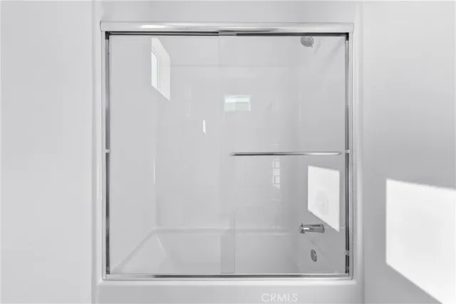 a bathroom with a glass shower door