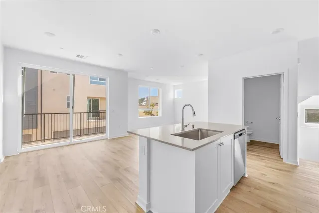 a kitchen with a sink and view of wooden floor