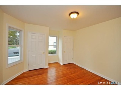 148 Alfred Street Bridgeport, CT 06605 - Photo 29 of 53 a view of an empty room with wooden floor and a window