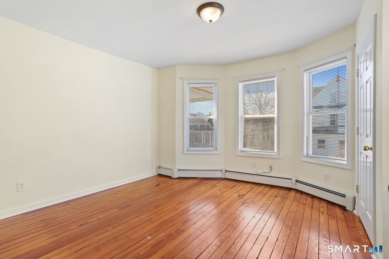148 Alfred Street Bridgeport, CT 06605 - Photo 39 of 53 an empty room with wooden floor and windows