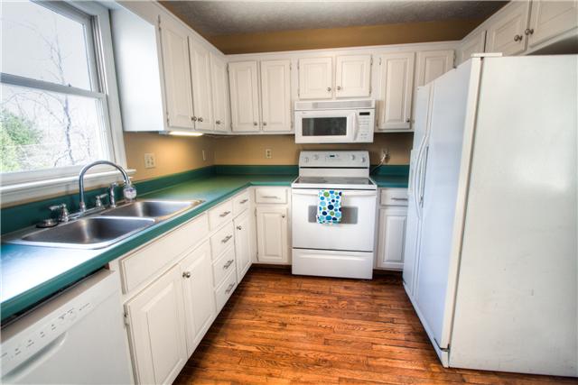 7358 Crow Cut Road Fairview, TN 37062 - Photo 7 of 18 a kitchen with white cabinets and white appliances